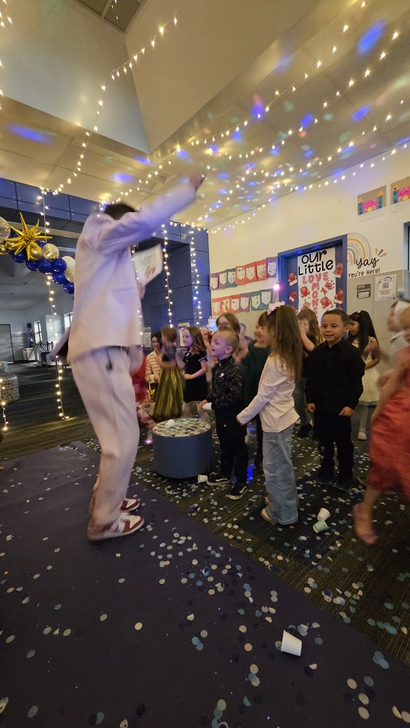 man in pink suit in front of group of students celebrating