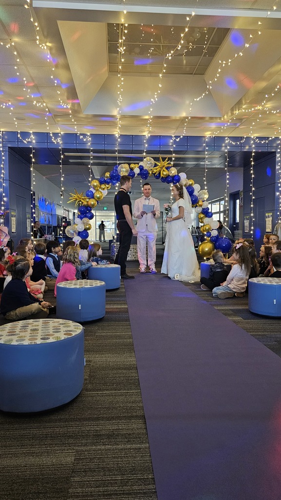 man and women with gown standing in front of group getting married