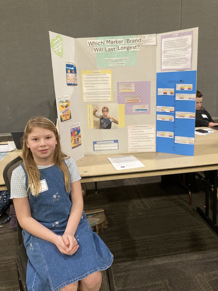 Student in front of science poster