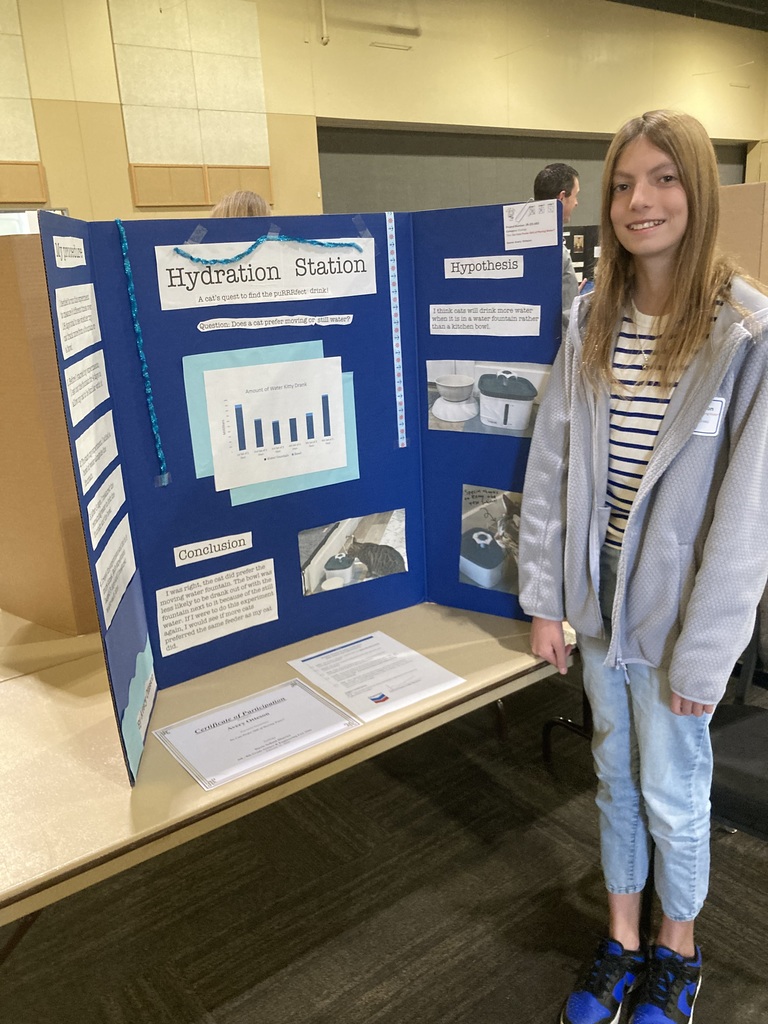 Student in front of science poster
