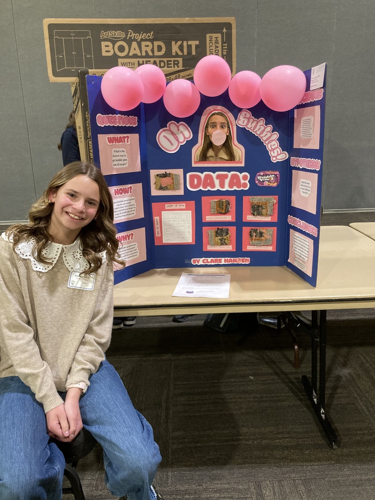 Student in front of science poster