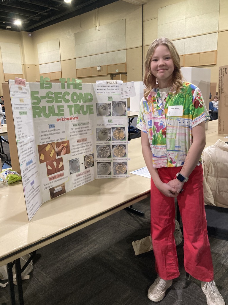 Student in front of science poster