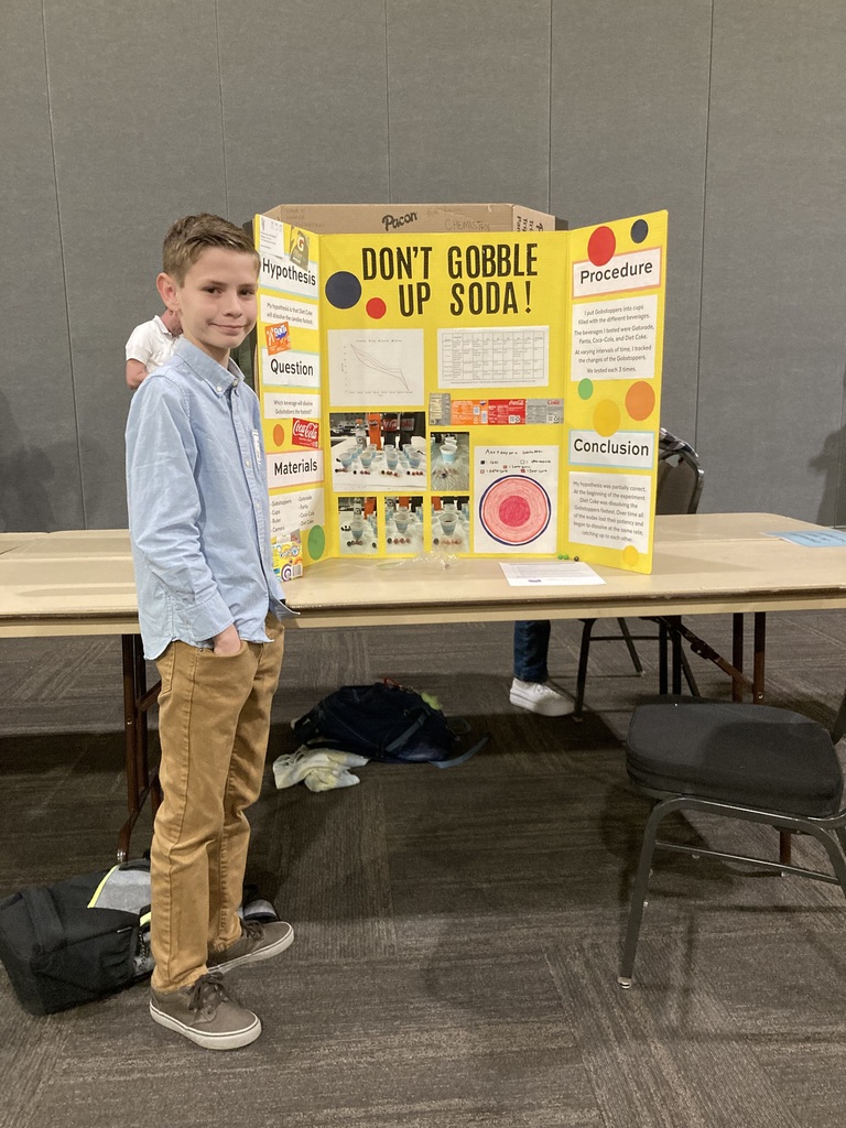 Student in front of science poster