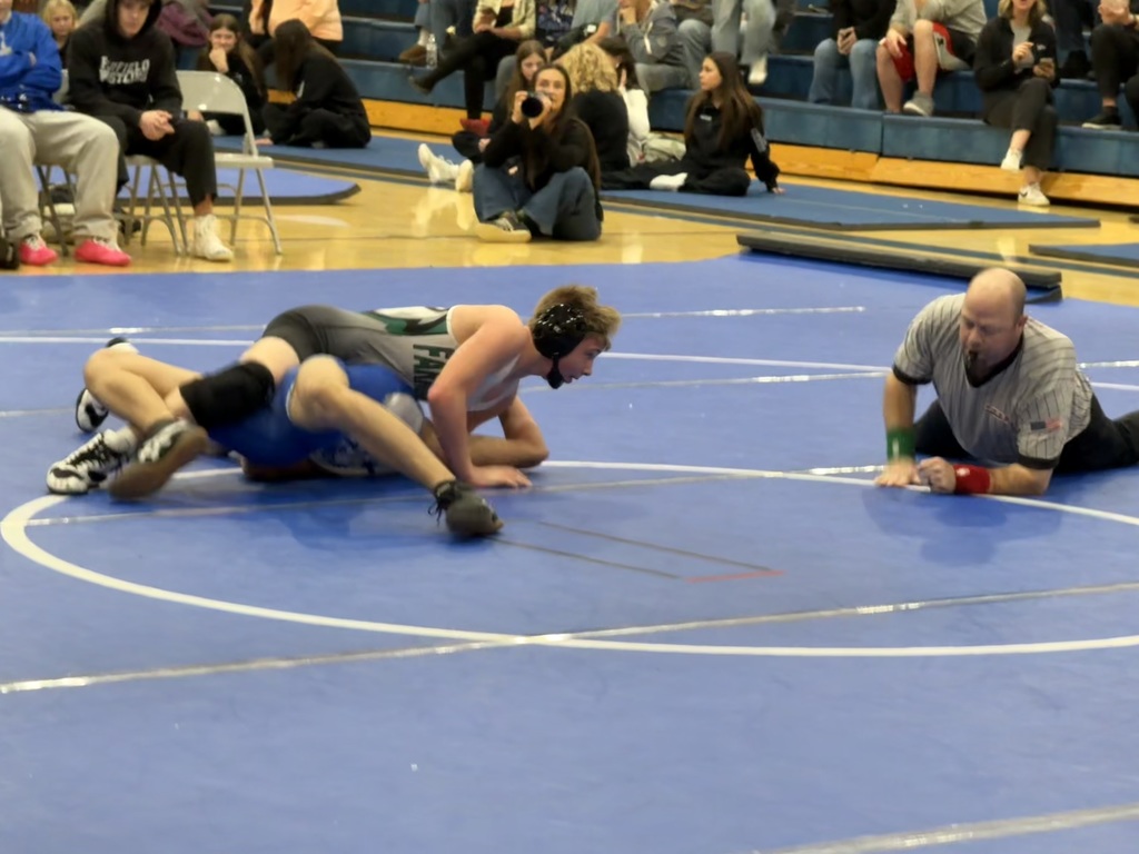 Wrestler pin in his opponent with referee verifying. 