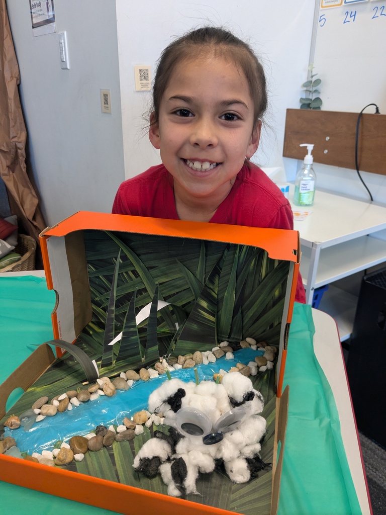 2nd Grader posing next to animal diorama. 