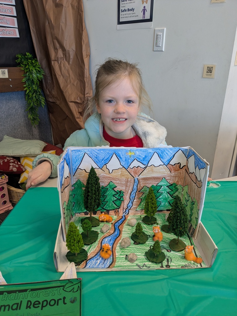 2nd Grader posing next to animal diorama. 