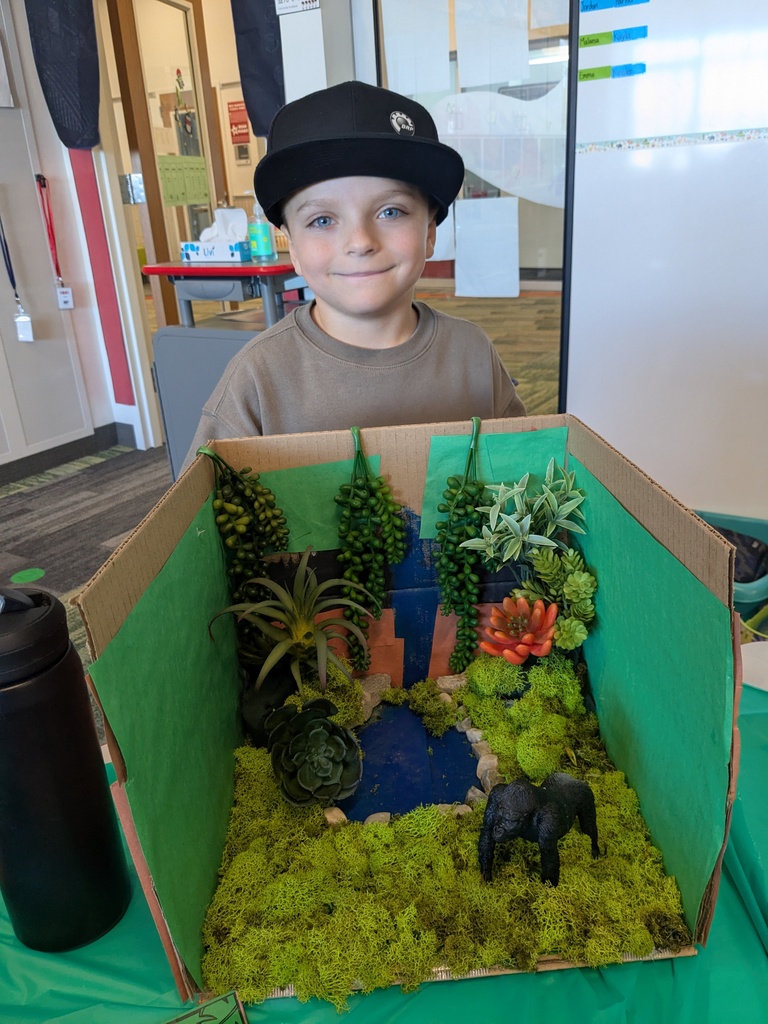 2nd Grader posing next to animal diorama. 