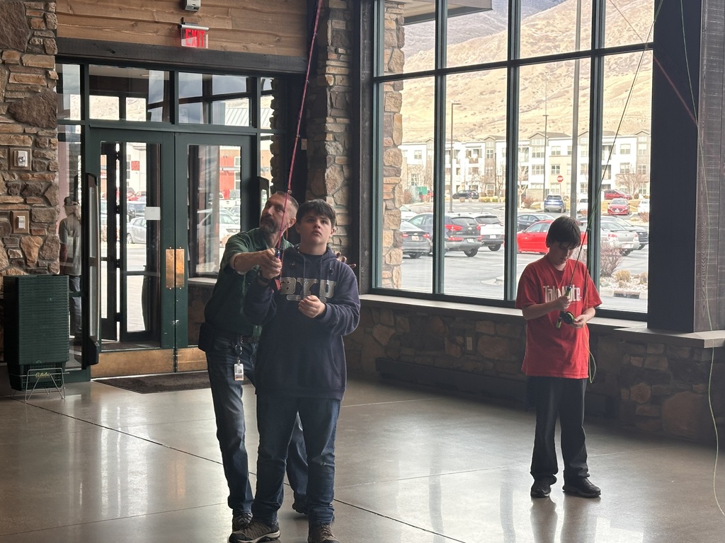 Students trying out fishing gear in Cabelas. 