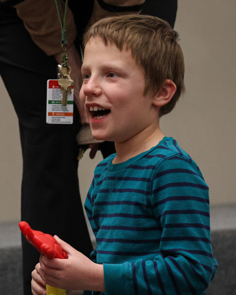 A student smiles while holding a rubber turtle.