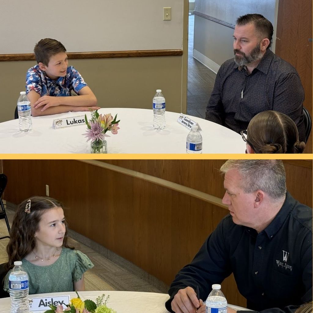 Students eating food and having a discussion at a round table with city leaders.