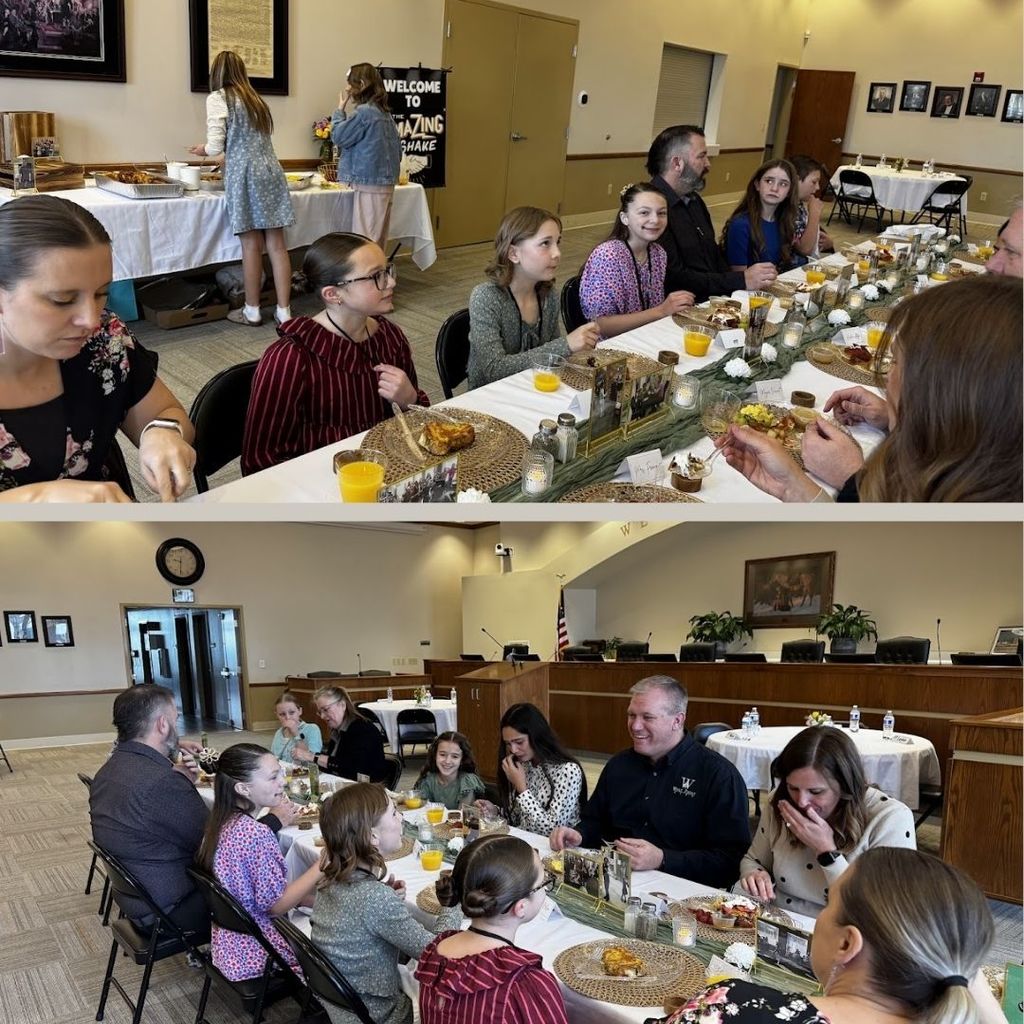 Students eating food and having a discussion at a round table with city leaders.