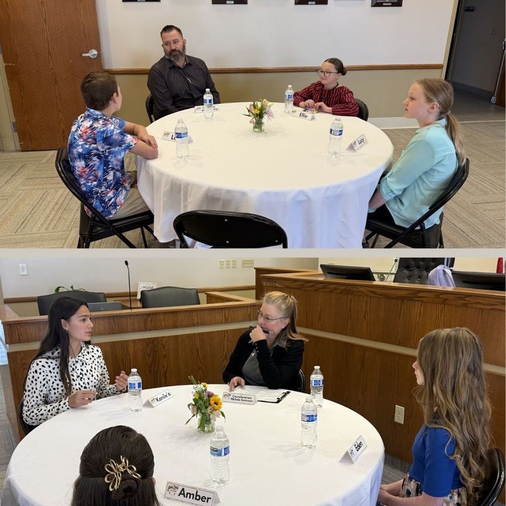 Students eating food and having a discussion at a round table with city leaders.