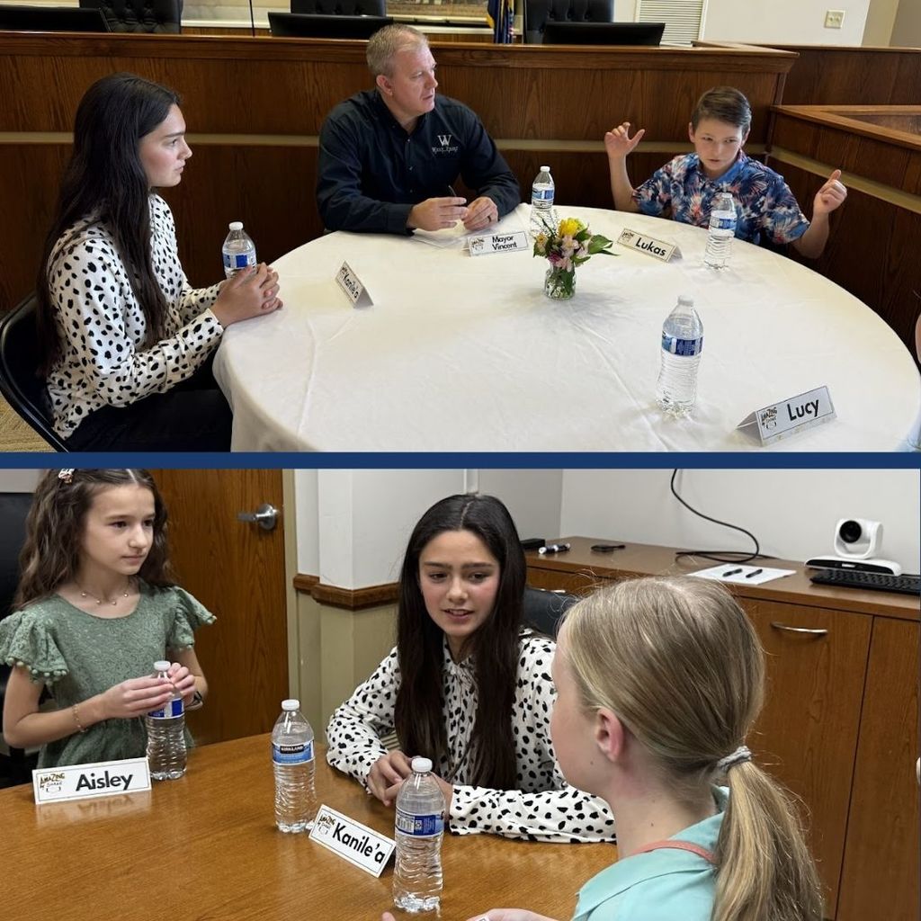 Students eating food and having a discussion at a round table with city leaders.