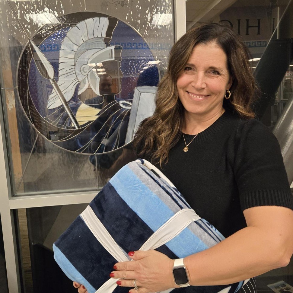 Mrs. Martini holding a Lancer blanket in front of a Lancer windows dressing