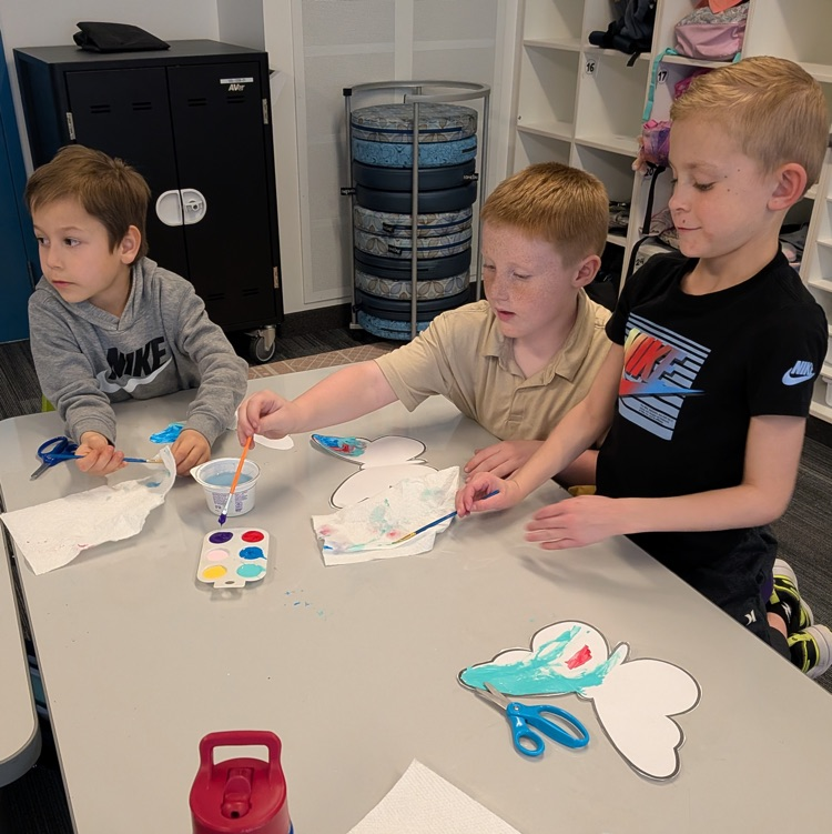 three boys using water colors to paint butterflies