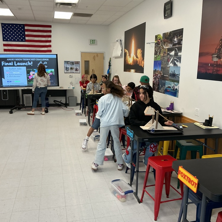 Students using trebuchets to test force and mass.