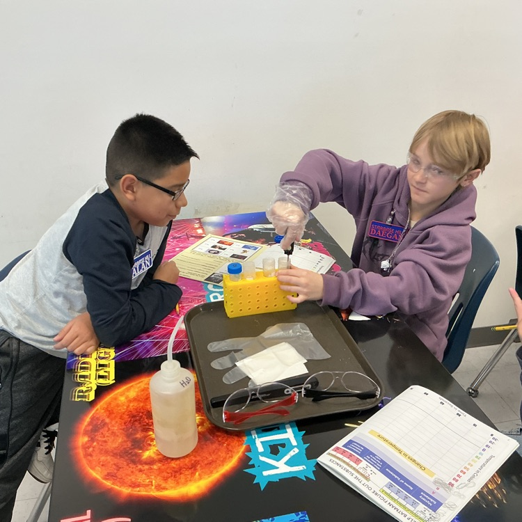 Students mixing a substance with water and taking the temperature of the substance every 15 seconds.