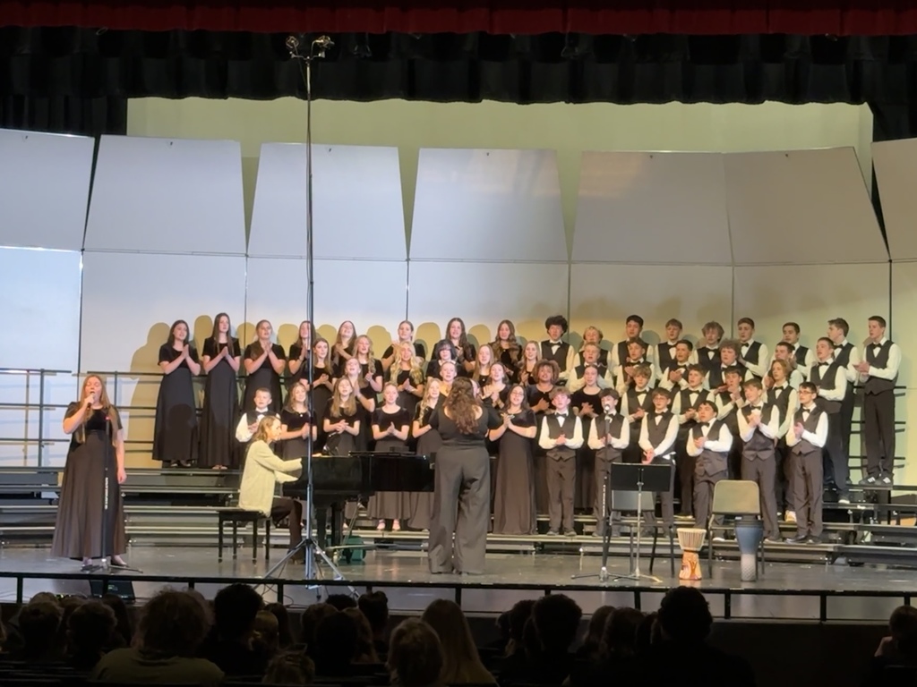Choir singing their final song while clapping. 