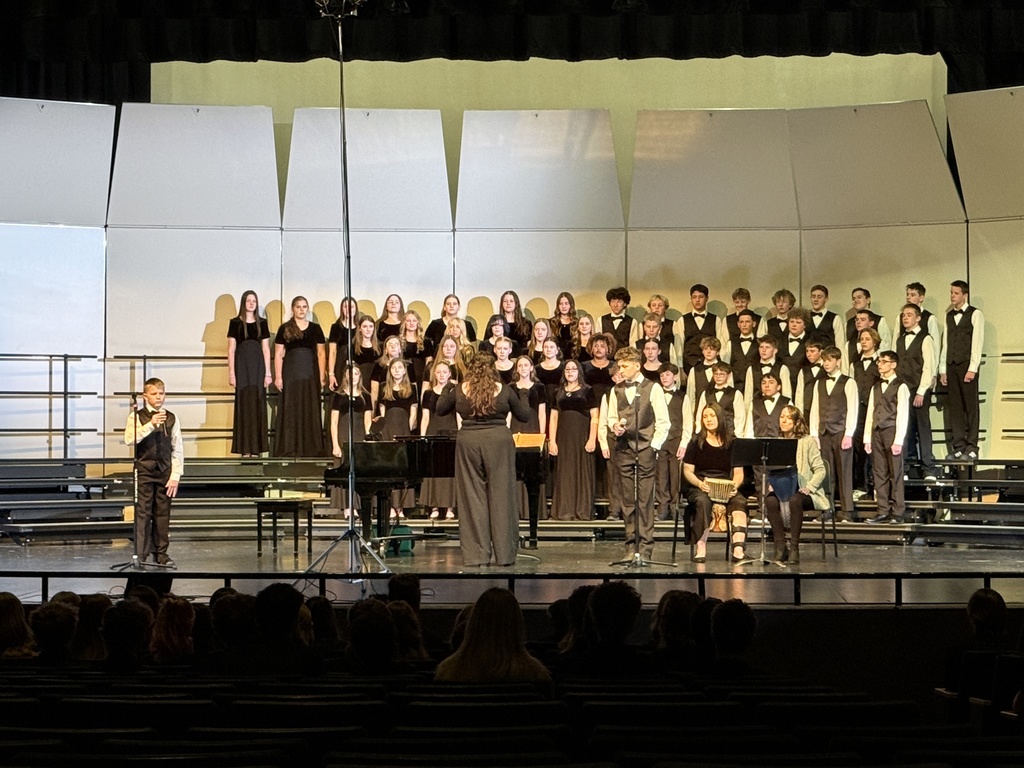 Students singing and playing the drums. 