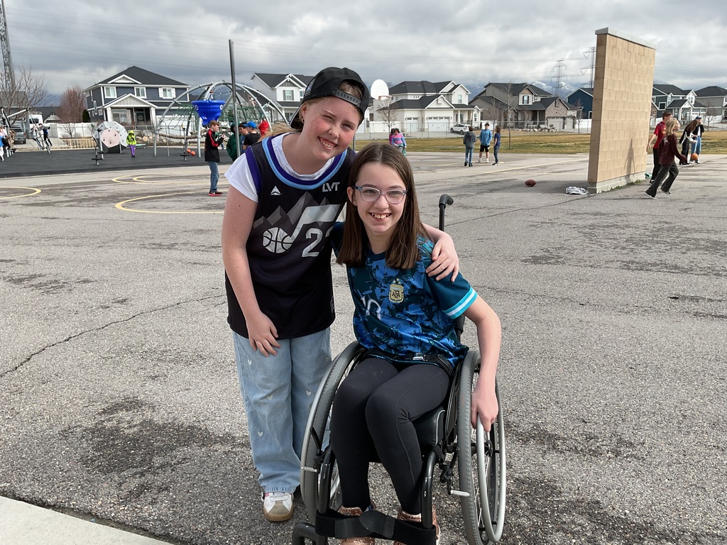 students photographed showing of their team apparel for Friendship & Inclusion Week.