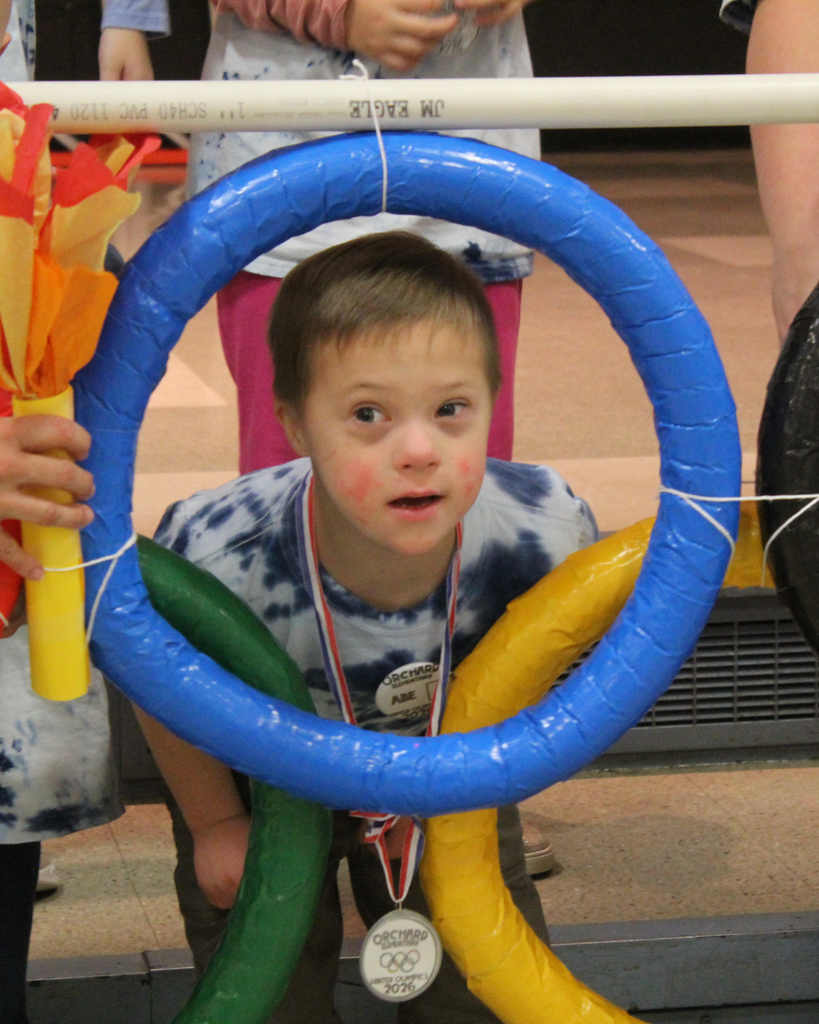 Student in the ASC program peers through the olympic rings at their ASC Olympics