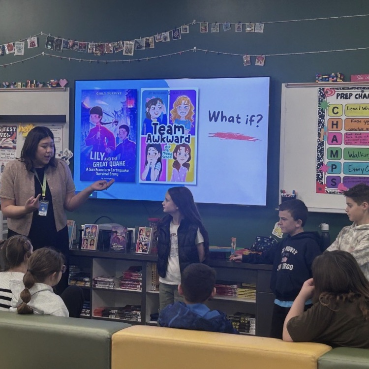 team awkward, what if? slide behind women and several children in a library 