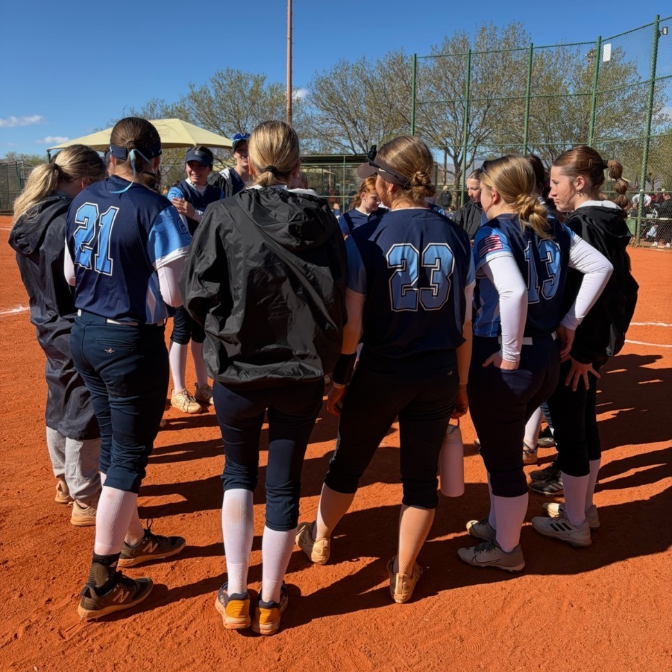 Lancer softball players talking in a huddle