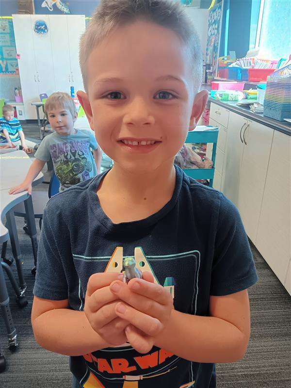 boy holding a 3d printed grey animal