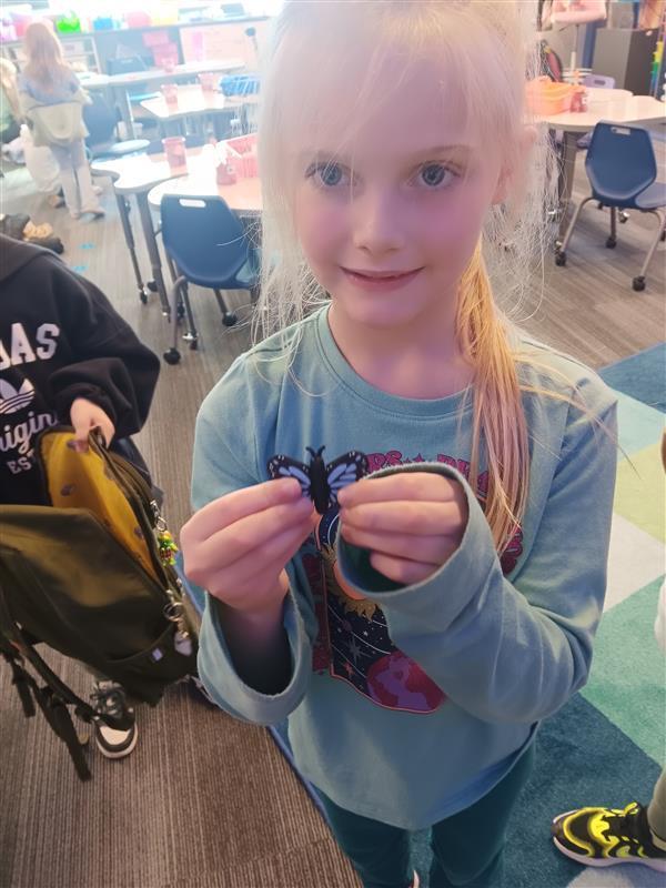 blonde girl with a 3d printed butterfly in her hand