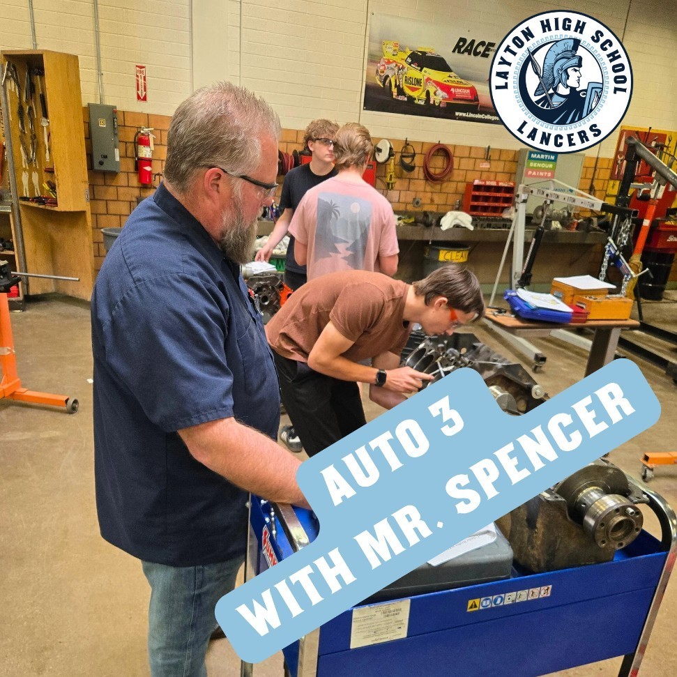 Mr. Spencer helping students as they rebuild engines