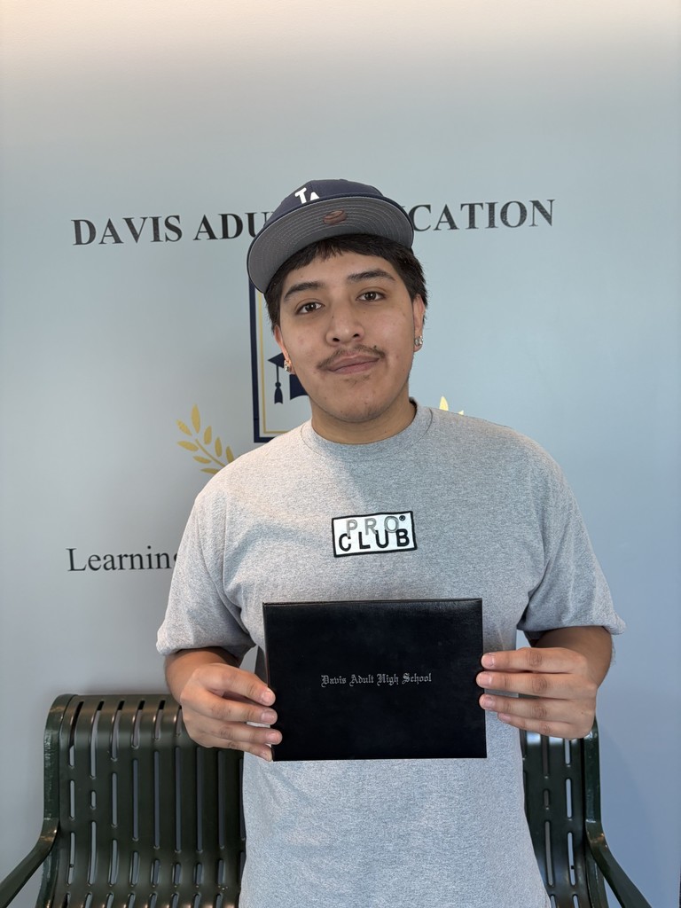 Kevin Rivas holding a diploma as he finished Adult High School