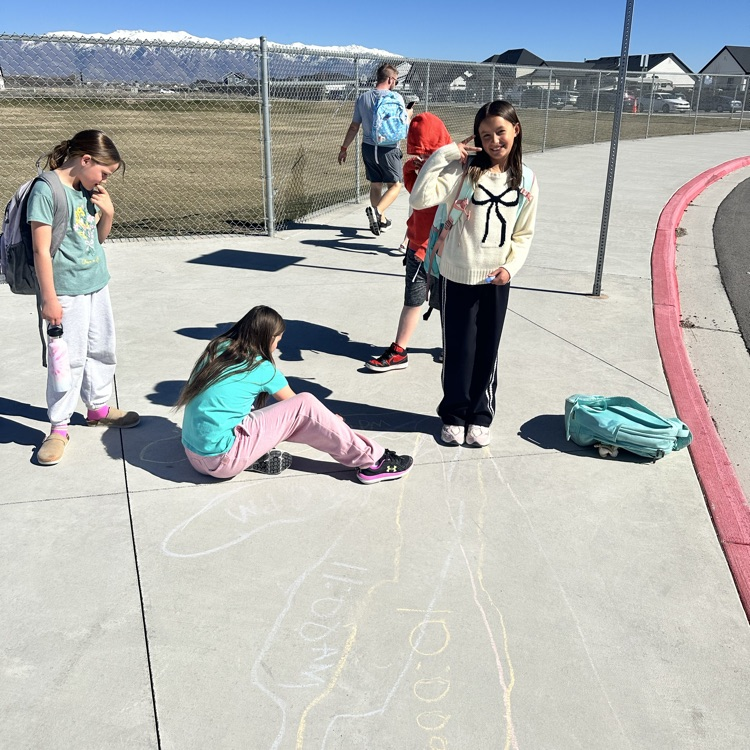 girl tracing another girls shadow on the ground