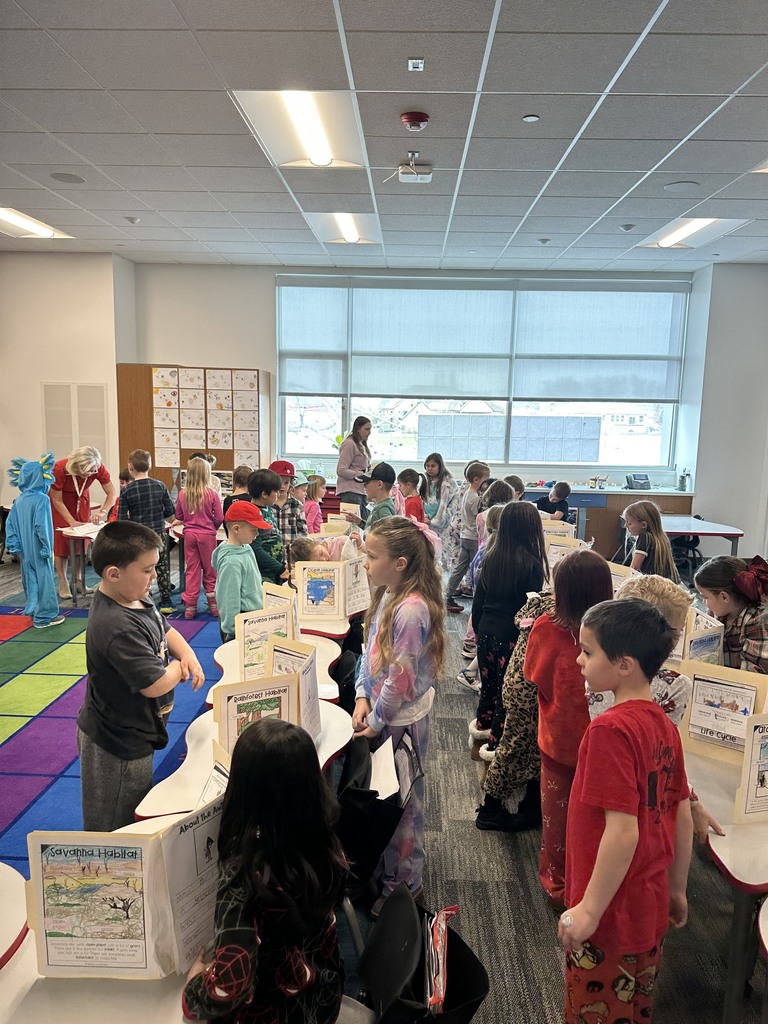 1st Graders standing next to their animal reports.