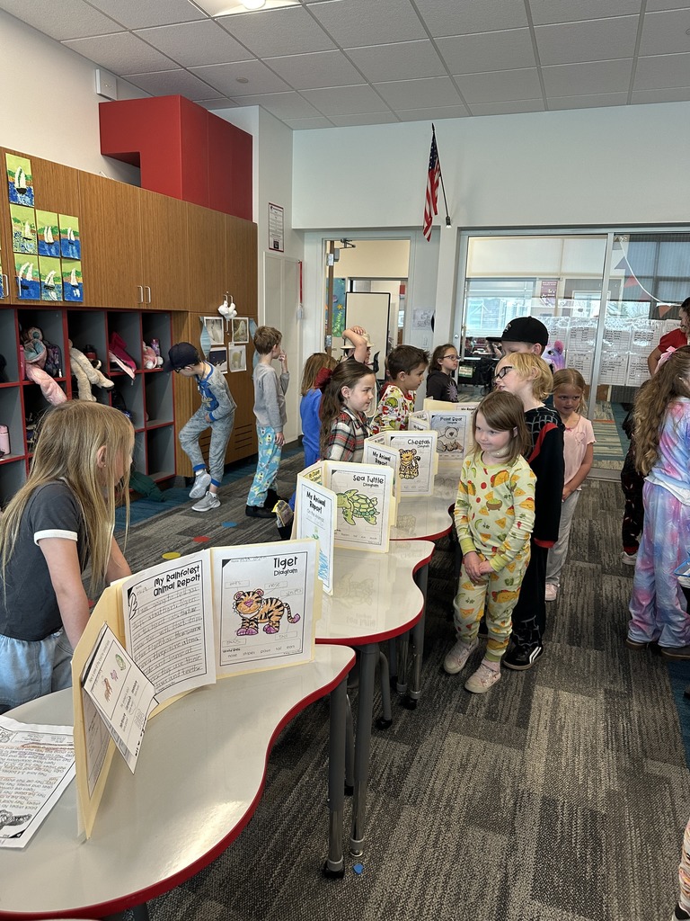 1st Graders standing next to their animal reports.