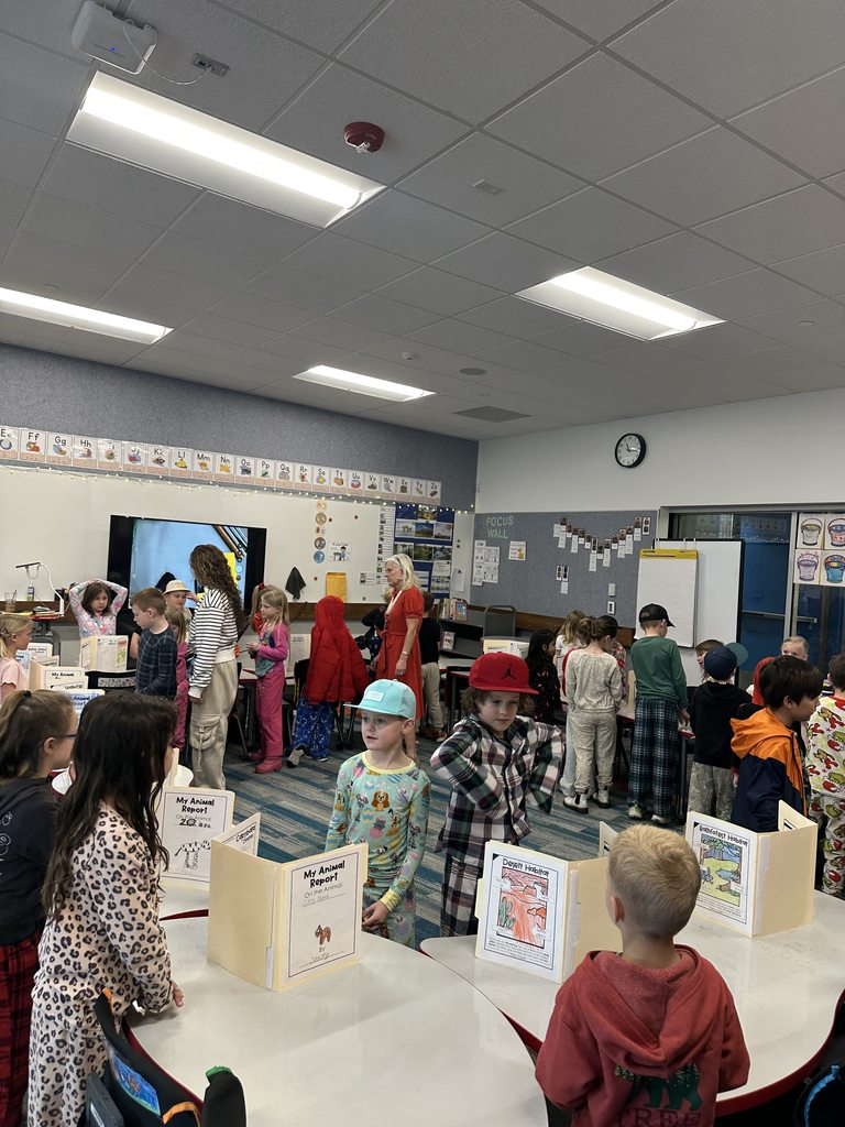 1st Graders standing next to their animal reports.