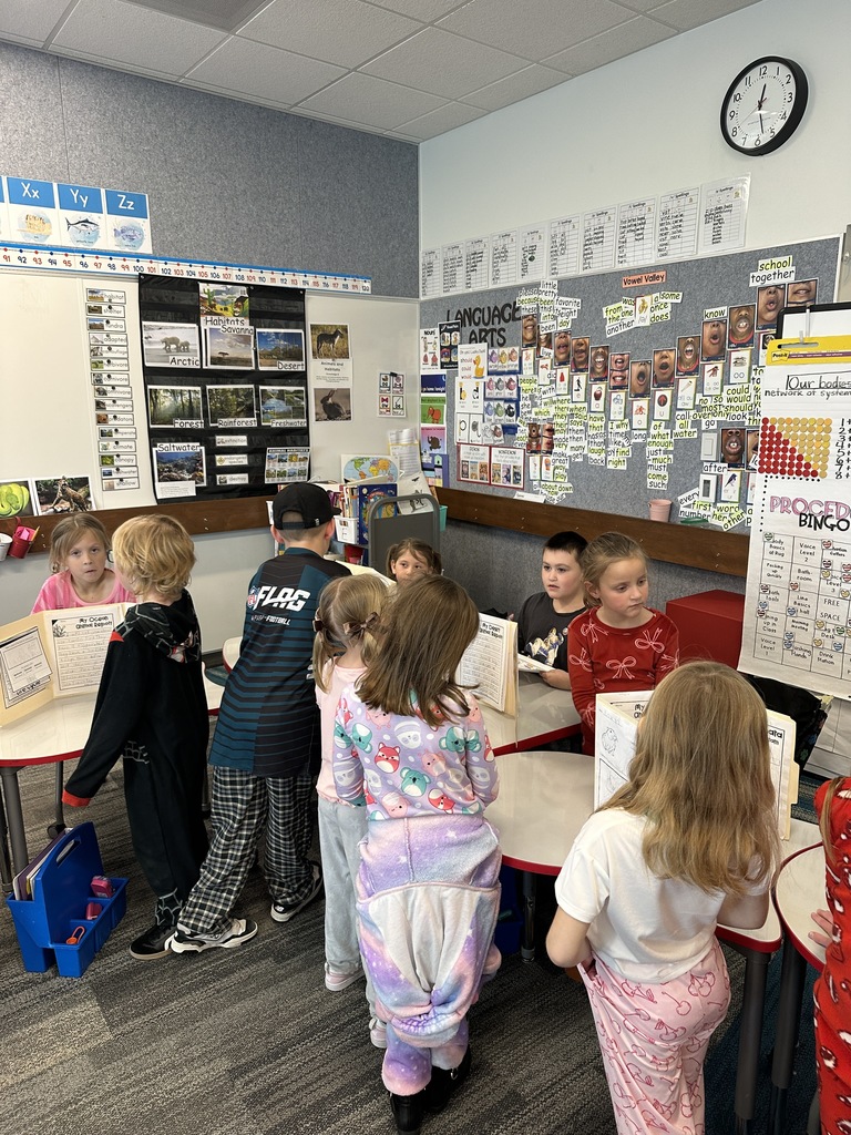 1st Graders standing next to their animal reports.
