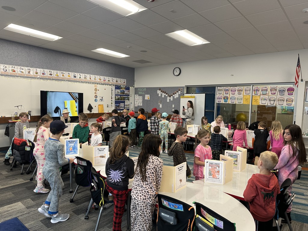 1st Graders standing next to their animal reports.