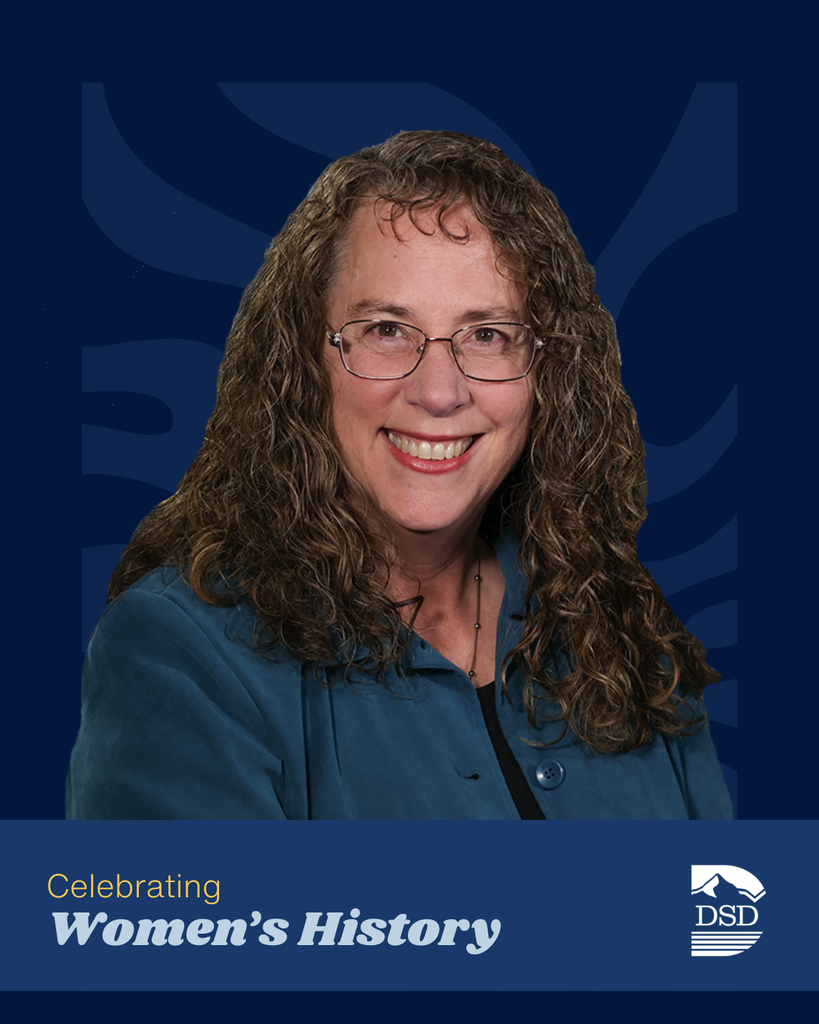 A staff member  smiling against a wavy background. A banner that reads: "Celebrating Women's History"  with the Central Davis Junior High and Davis School District Logos.