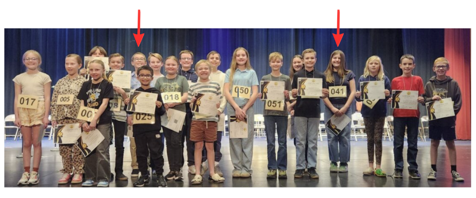 Students pictured on a stage holding certificates.