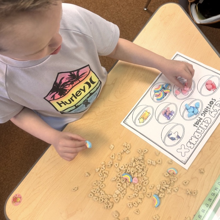 kindergartners doing a math and writing activity on St. Patrick’s day