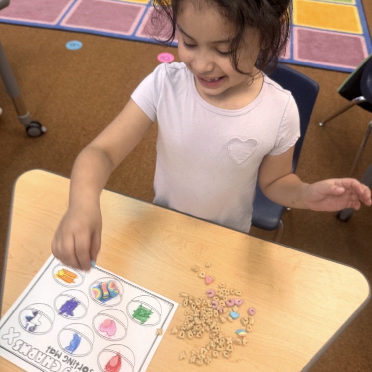 kindergartners doing a math and writing activity on St. Patrick’s day