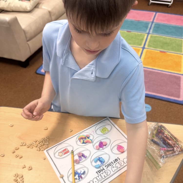 kindergartners doing a math and writing activity on St. Patrick’s day