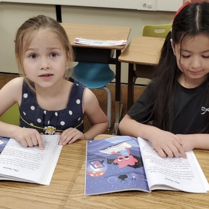 1st graders reading together with a partner to practice their skills