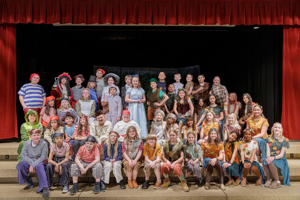 Peter Pan Cast sitting on stage steps