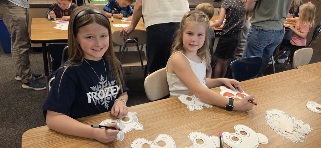 A photo ol children show off their projects from wild about arts night.