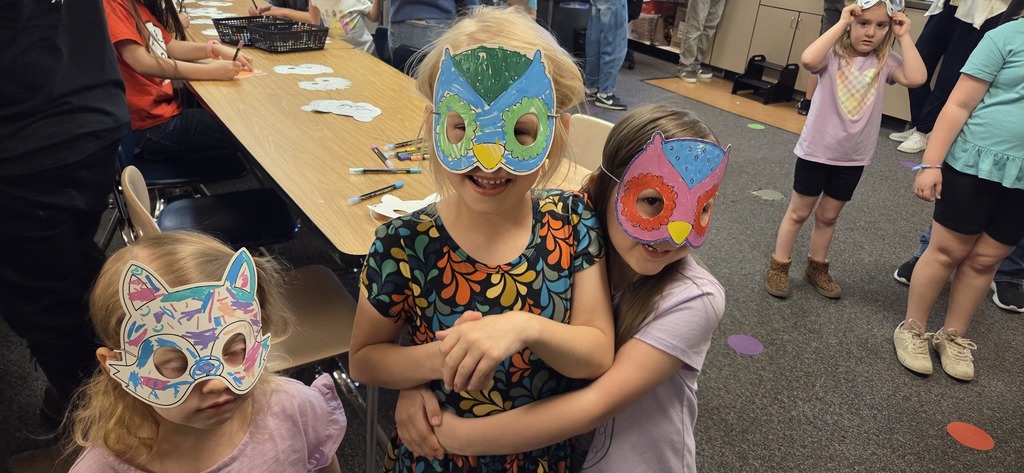 A photo ol children show off their projects from wild about arts night.