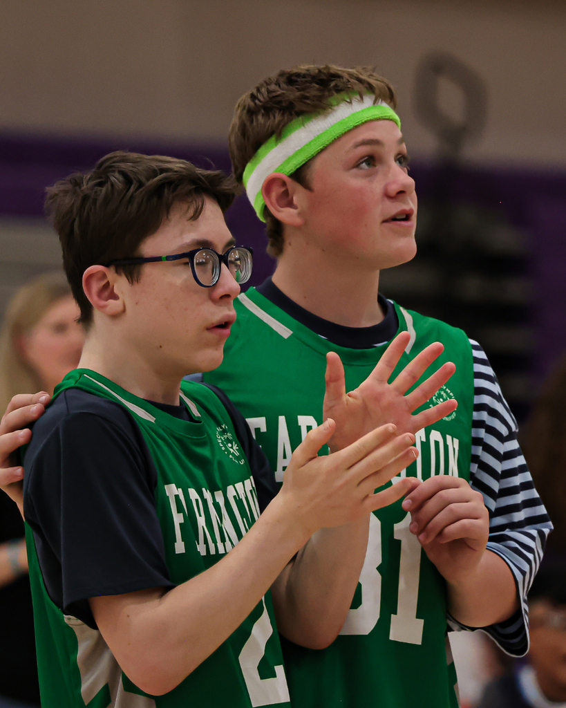 Two Farmington Junior High students wearing green jerseys look to the left. 