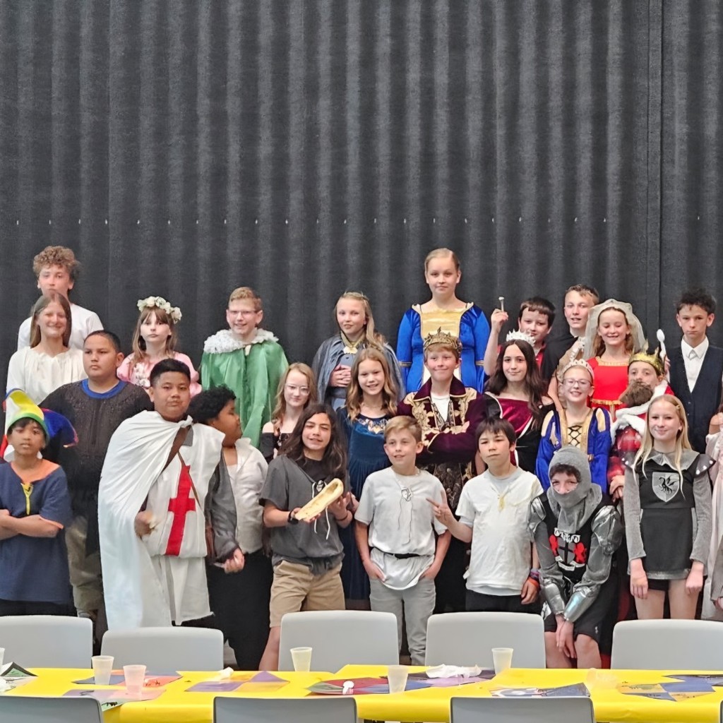 Students dressed as medieval nobles and villagers pose together at Bountiful Elementary’s 6th grade Medieval Feast celebration.
