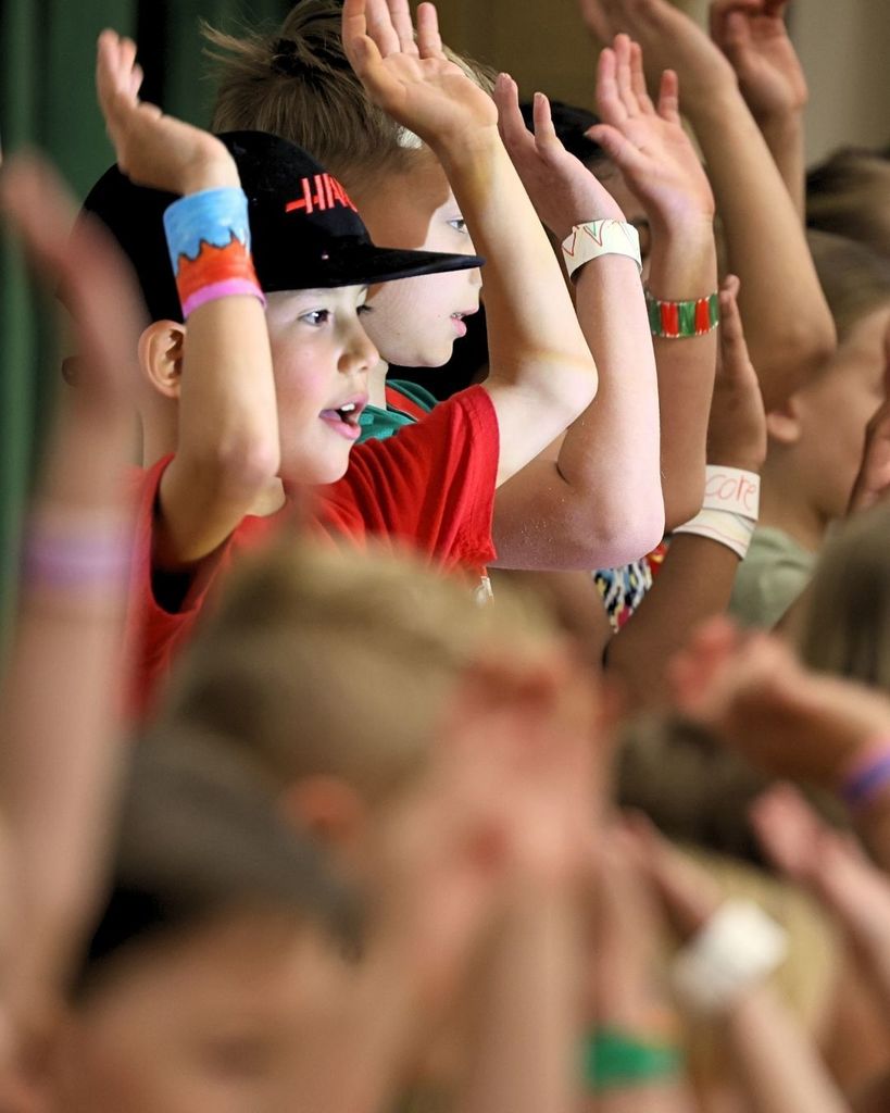 Students singing wearing paper bracelets.