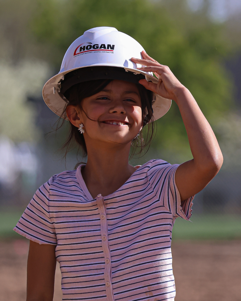 A student wearing a Hogan helmet smiling during the Kaysville Field House Groundbreaking.